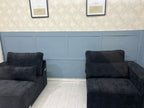 Black modular footstools with plush cushions in a modern, light-toned living room setting.