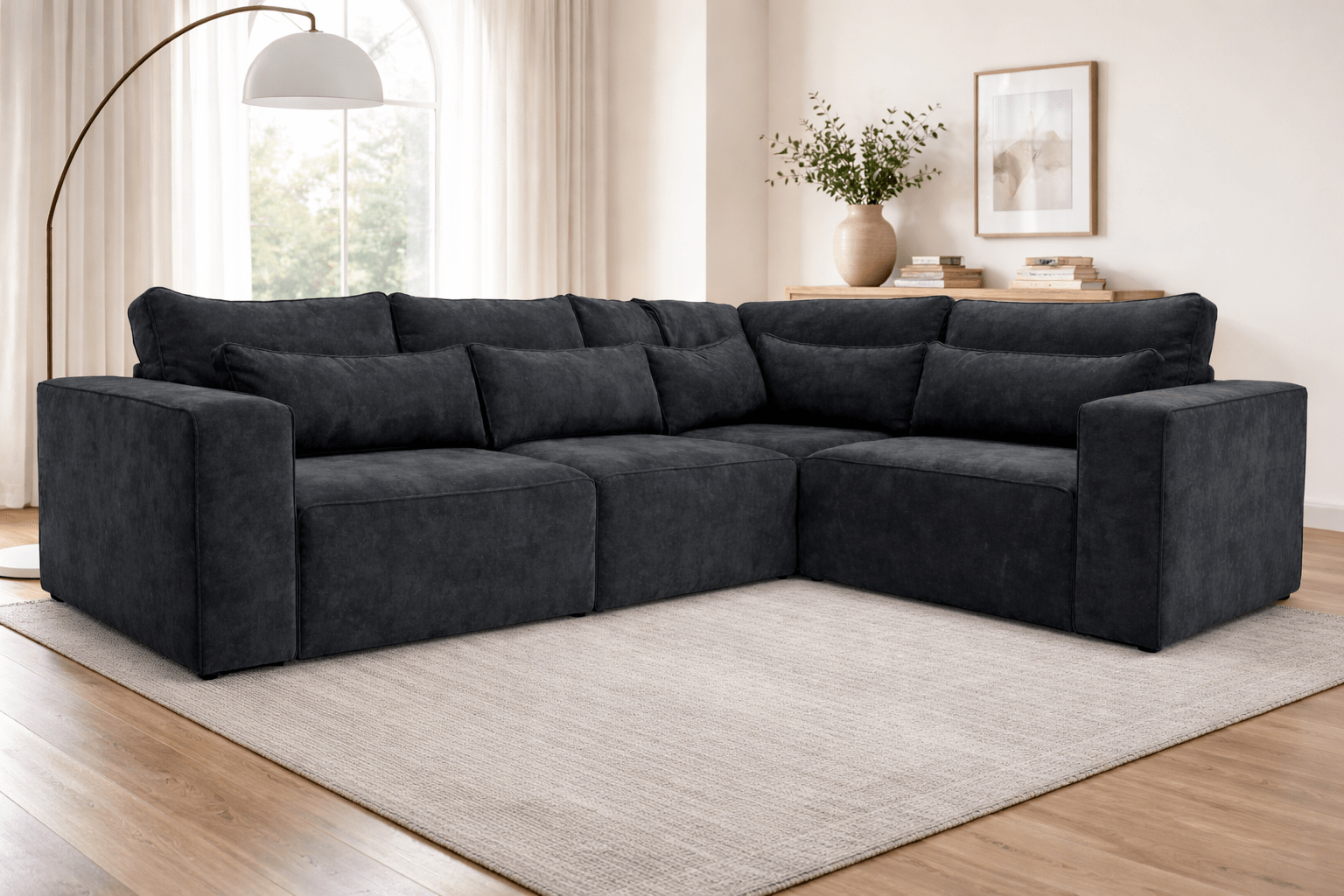 Black modular corner sofa with plush cushions in a modern living room setting