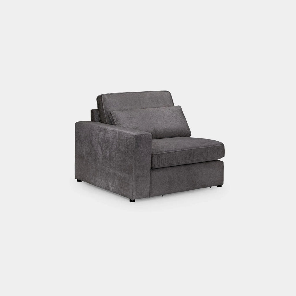 Modern grey modular sofa section with one armrest and plush cushions on white background