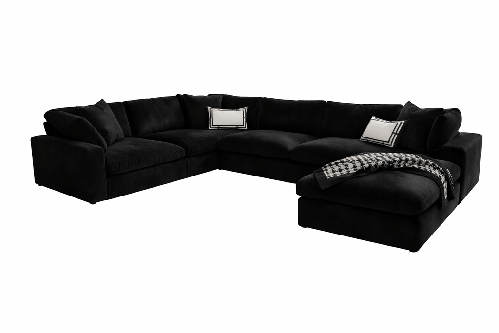 Large black U-shaped modular sofa with footstool, scatter cushions and a houndstooth throw.