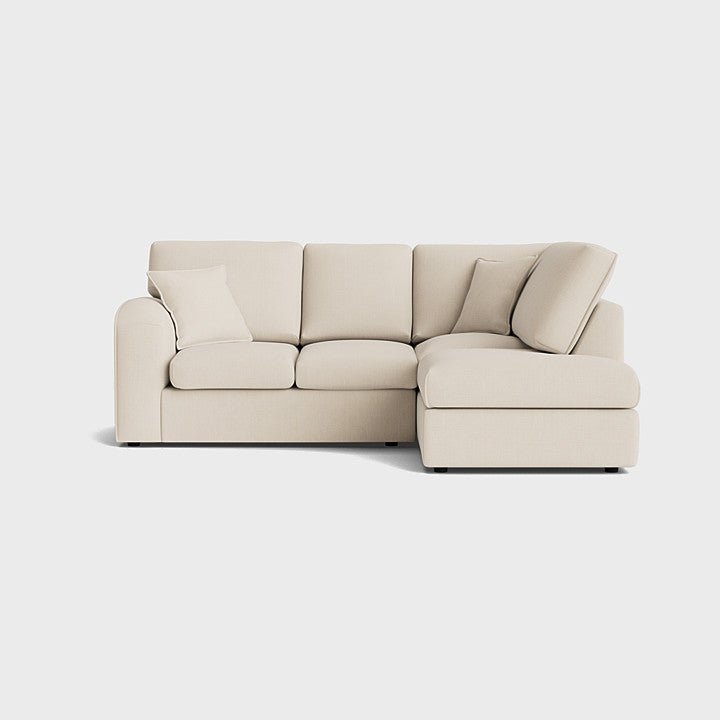 Modern cream right corner sofa with chaise and cushions on light background