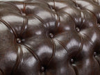 Close-up of chesterfield sofa tufted antique brown leather upholstery