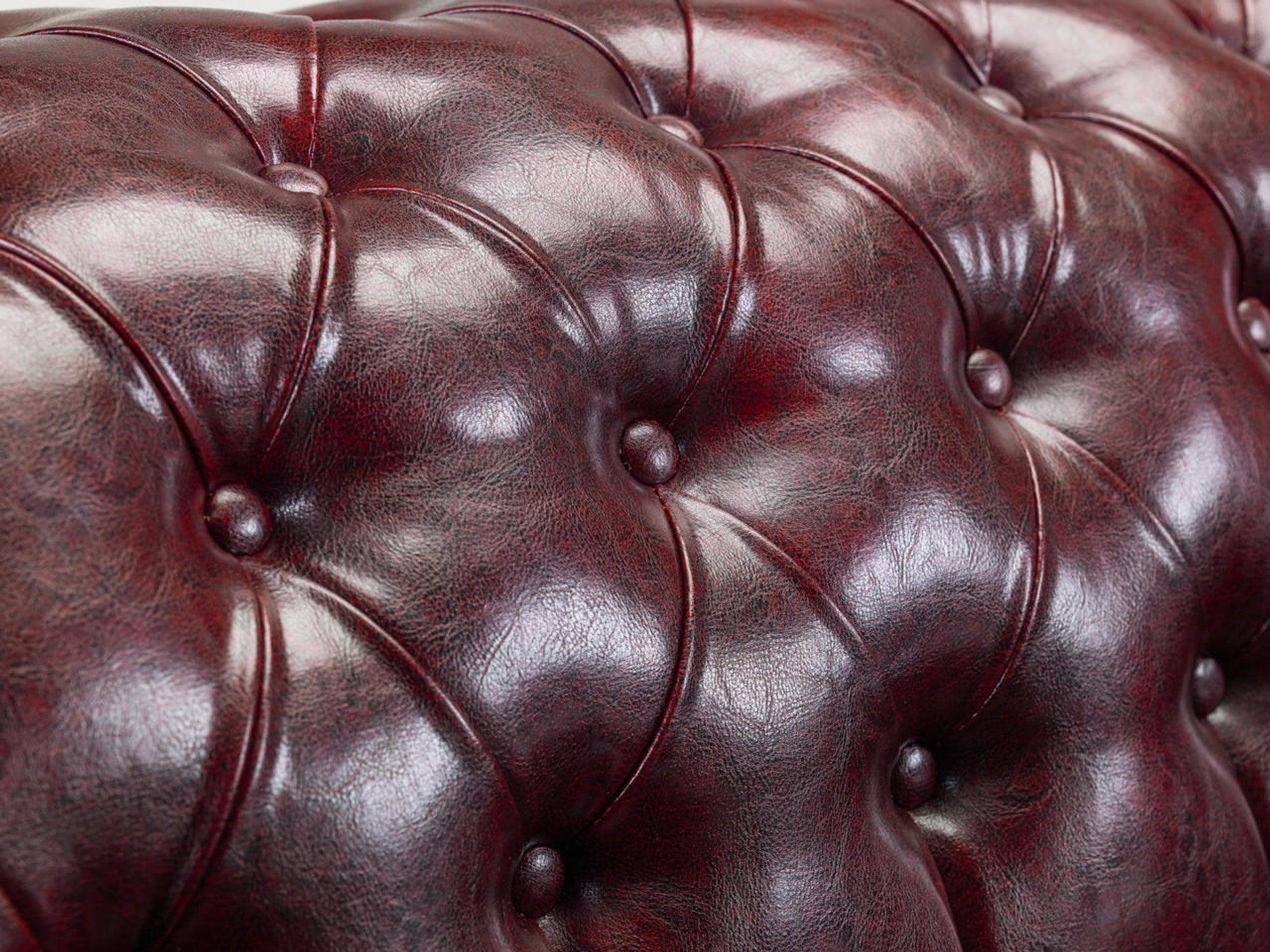 Close-up of a tufted oxblood chesterfield leather sofa backrest