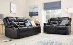 Modern living room with black leather reclining sofas, decorative cushions, and large window