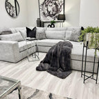 4-piece ash grey corner sofa in modern living room with cushions and faux fur throw