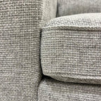 Close-up of ash grey textured fabric on a modern corner sofa cushion