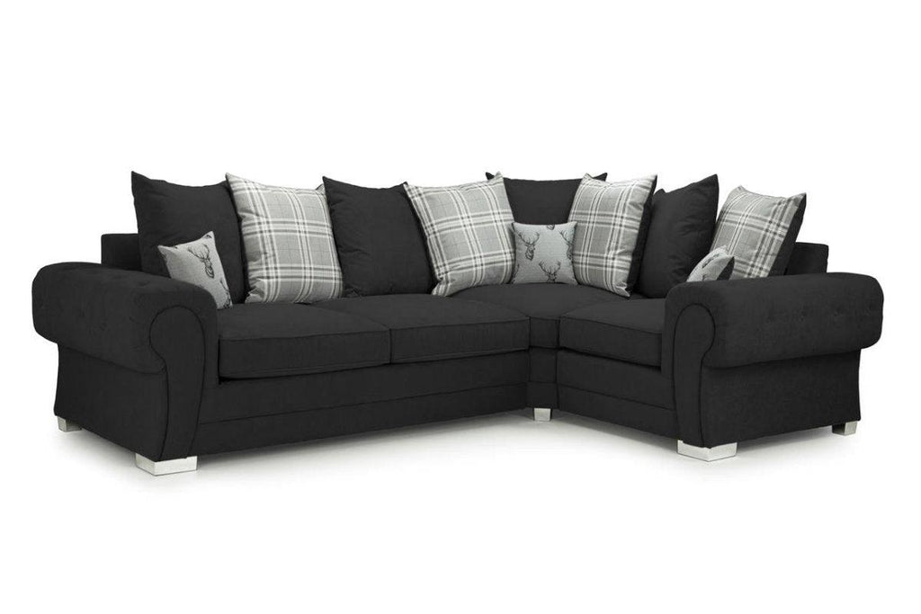 Black corner sofa with rolled arms, plaid and deer scatter cushions, left facing, white background