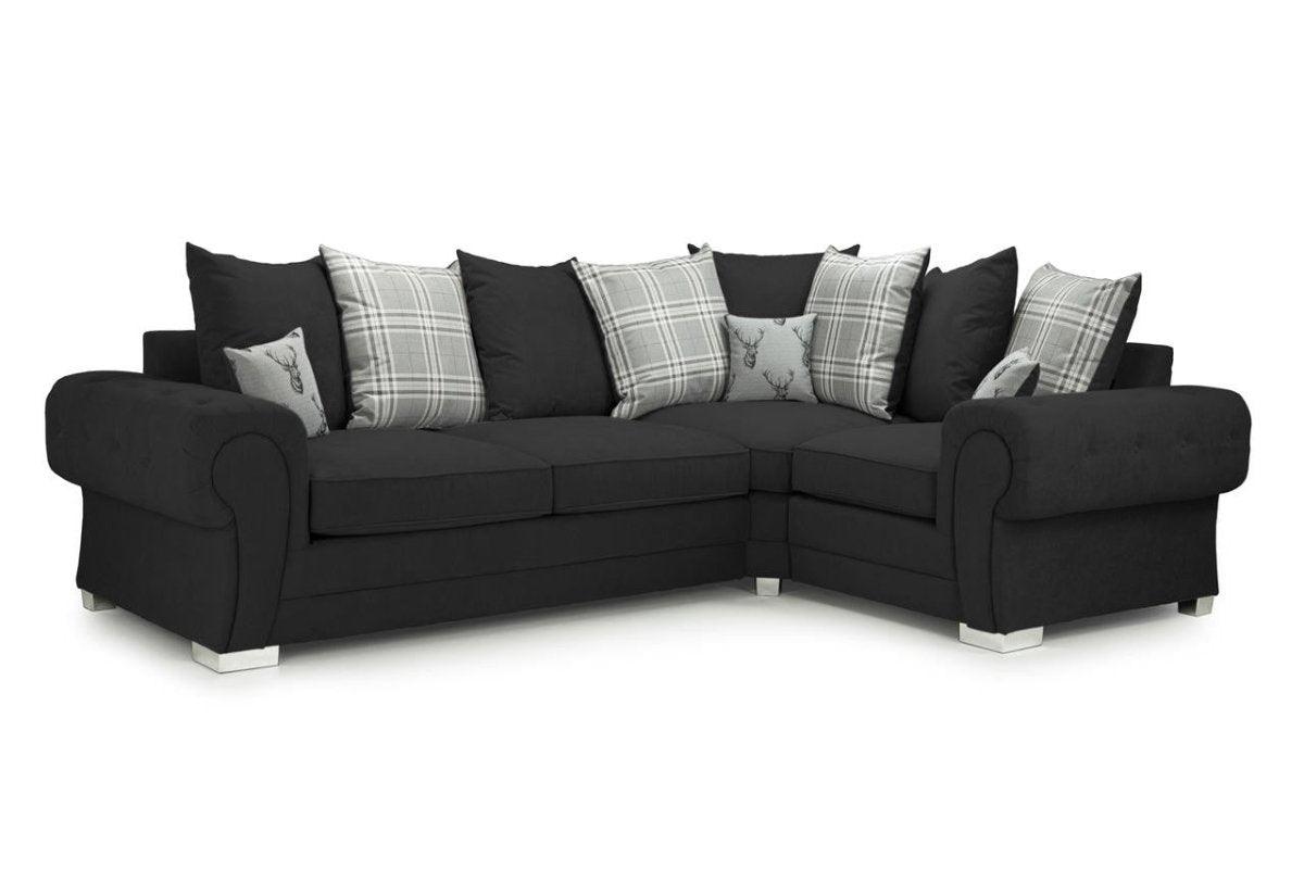 Black corner sofa with rolled arms, plaid and deer scatter cushions, left facing, white background