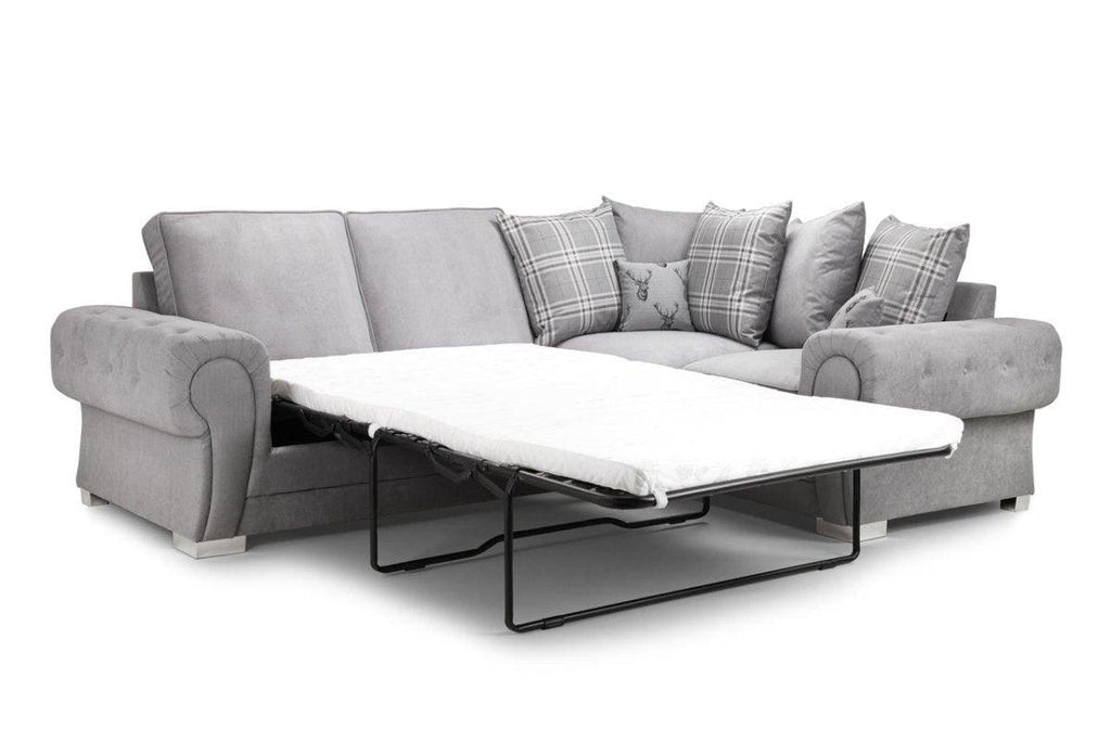 Light grey corner sofa bed with plaid and deer scatter cushions, pull-out mattress extended
