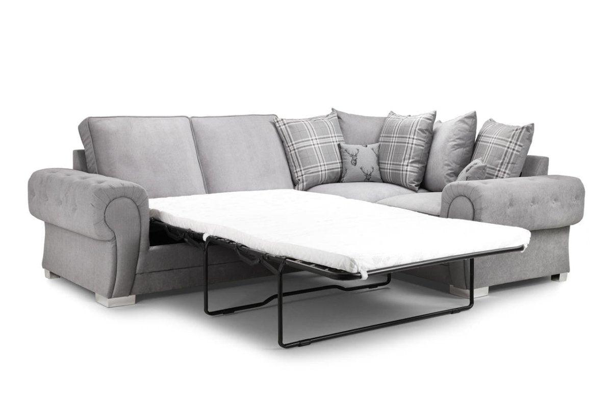Light grey corner sofa bed with plaid and deer scatter cushions, pull-out mattress extended
