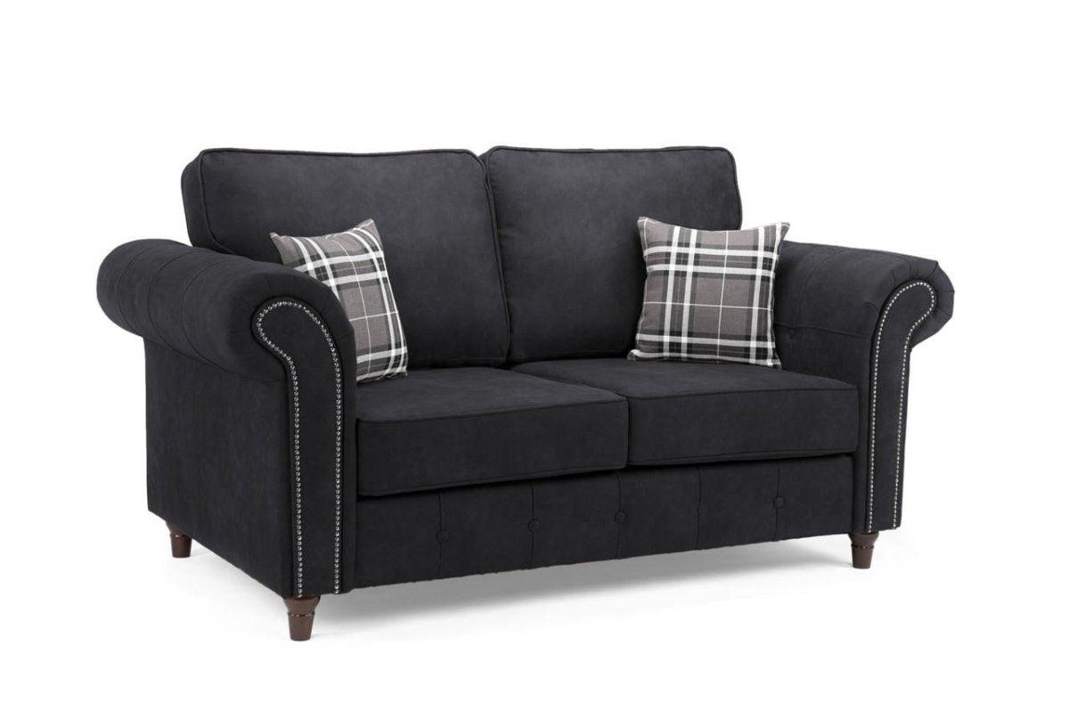 Black two-seater sofa with rolled arms, studded trim, and plaid scatter cushions