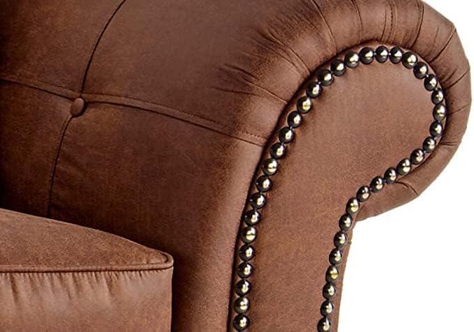 Close-up of brown leather sofa armrest with decorative nailhead trim and tufted detail