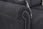 Black fabric sofa with rolled armrest, silver stud detailing, and plaid cushions