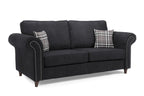 Black three-seater sofa with rolled arms, stud detailing, and two plaid accent pillows.