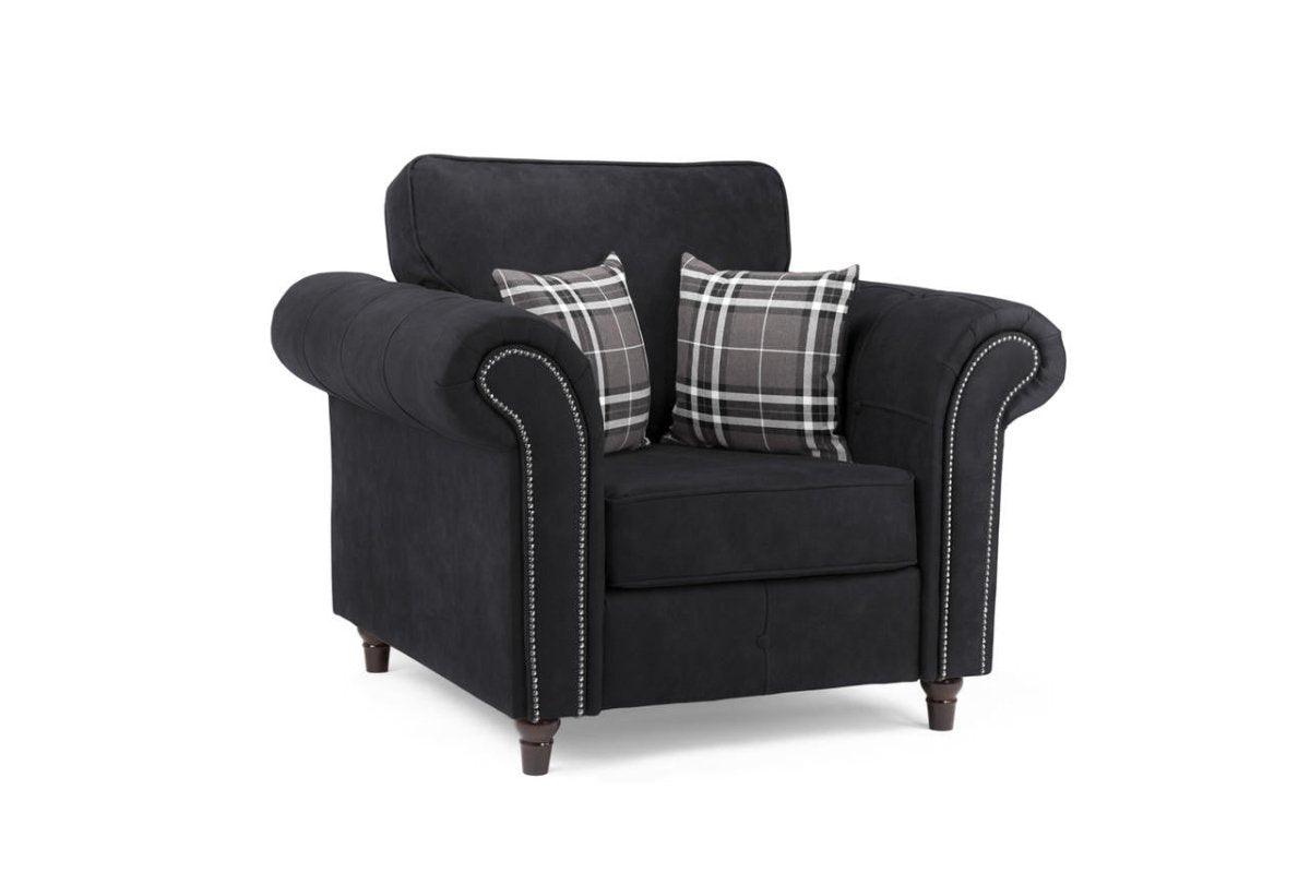 Black one-seater armchair with plaid accent pillows and studded rolled arms on white background