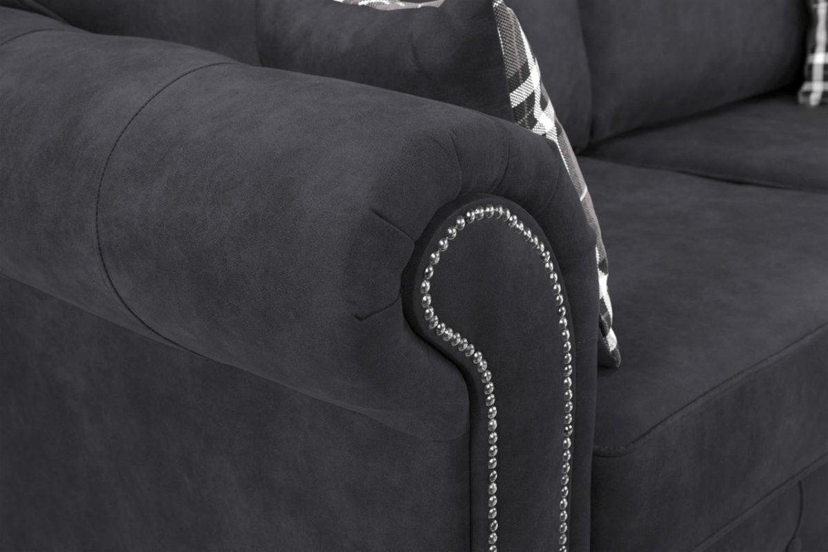 Black velvet armchair with rolled armrest, silver nailhead trim, and plaid cushion