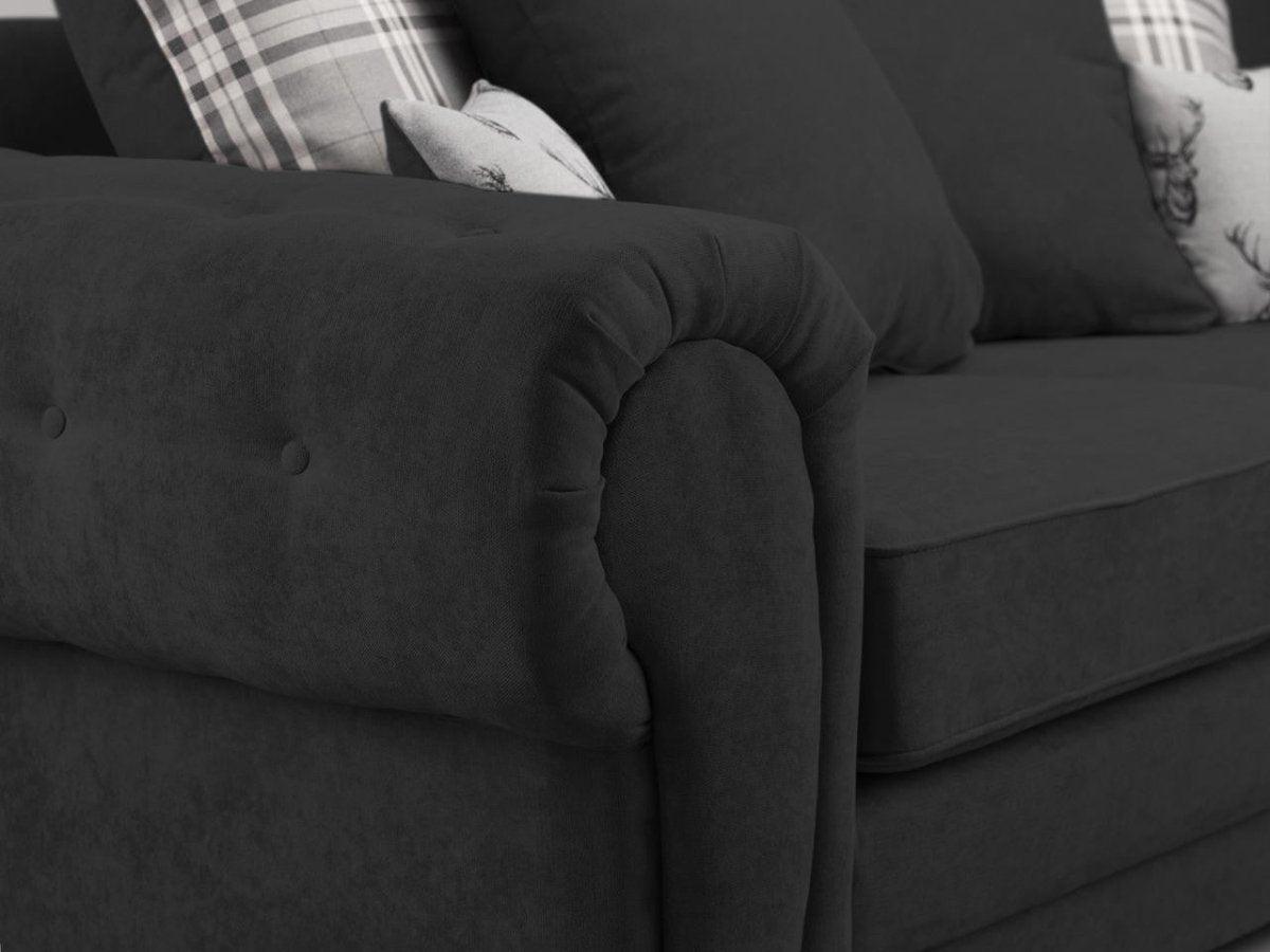 Close-up of black fabric sofa with plush cushions and plaid accent pillows