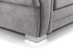 Close-up of a grey fabric sofa with chrome metal legs on a light floor