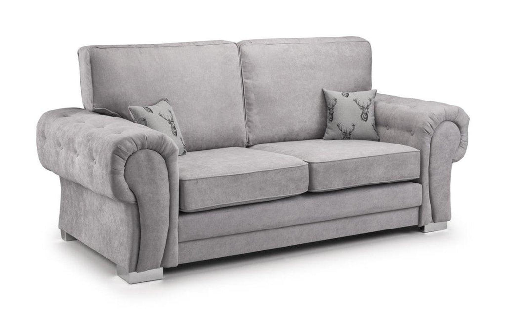 Light grey three-seater sofa with tufted arms and two patterned accent cushions