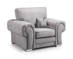 Plush grey velvet armchair with rolled arms and patterned accent cushion, modern style.