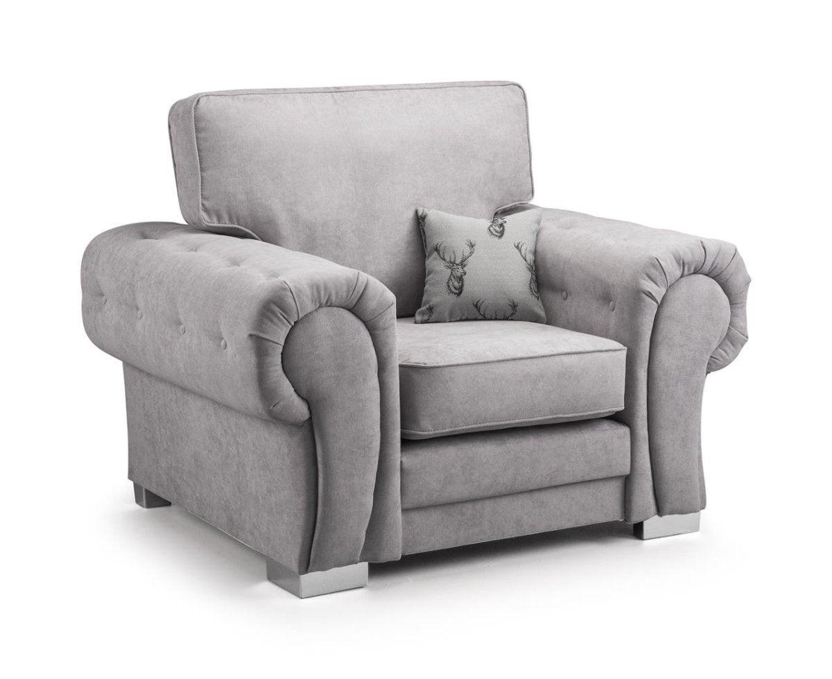 Plush grey velvet armchair with rolled arms and patterned accent cushion, modern style.
