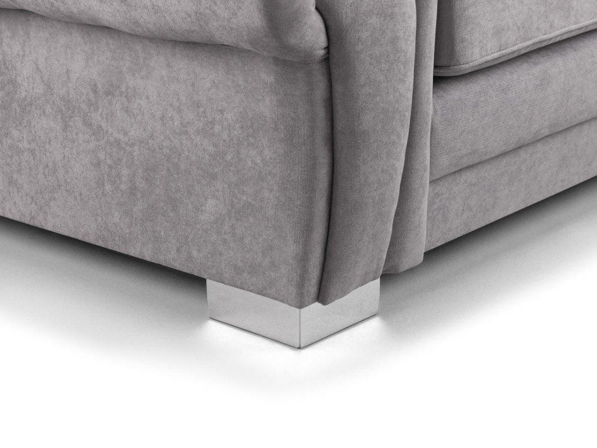 Close-up of grey velvet sofa corner with chrome square legs on a white background