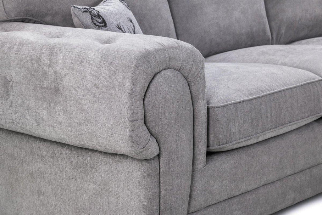 Close-up of a grey fabric sofa armchair with plush cushions and a decorative pillow