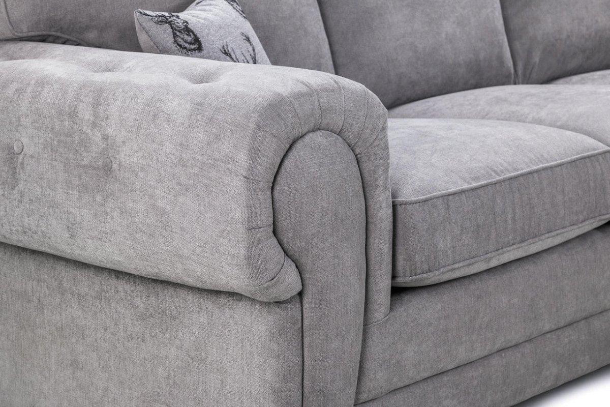 Close-up of a grey fabric sofa armchair with plush cushions and a decorative pillow
