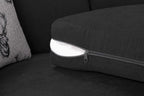 Close-up of black corner sofa cushion with exposed inner filling and zippered cover