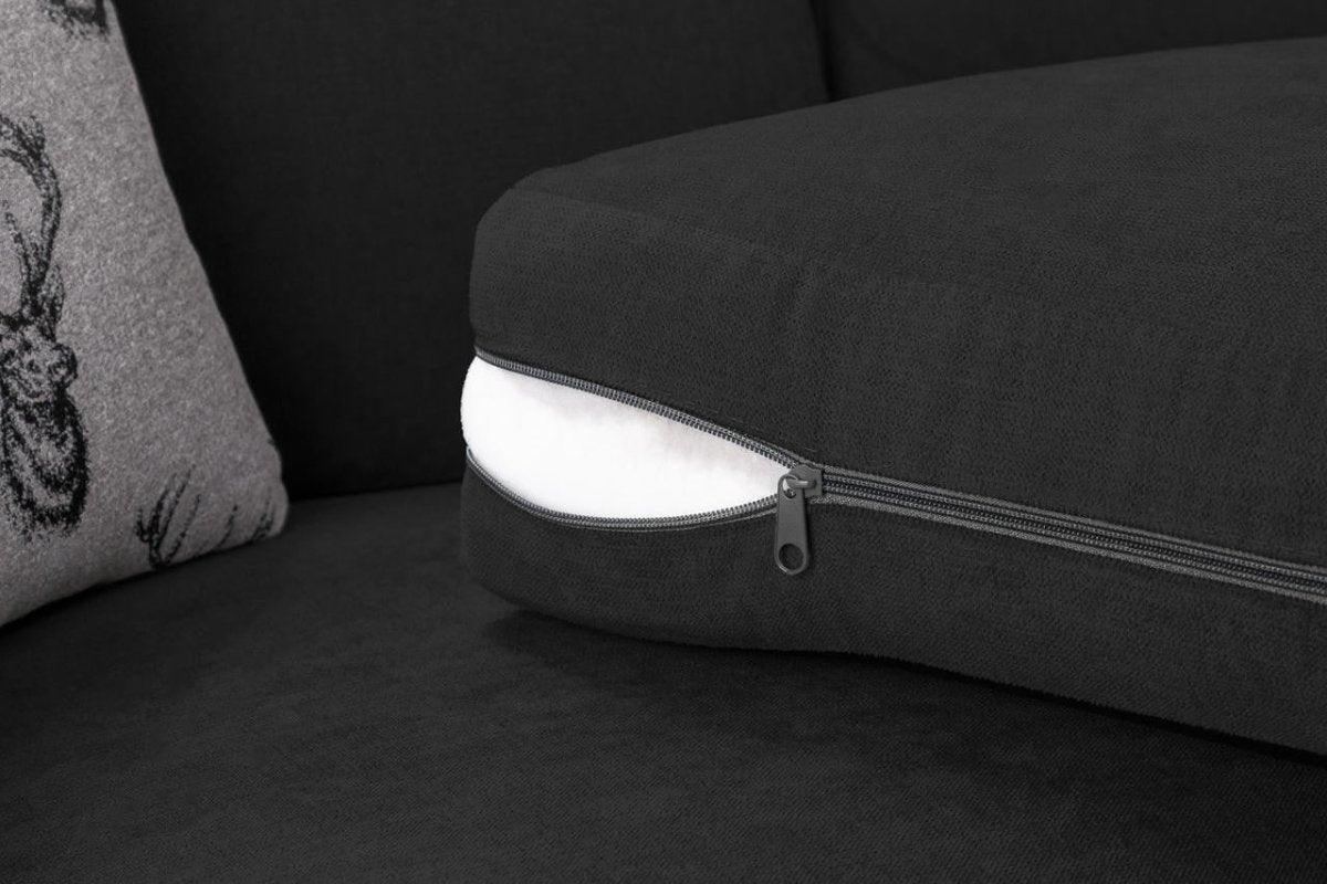 Close-up of black corner sofa cushion with exposed inner filling and zippered cover