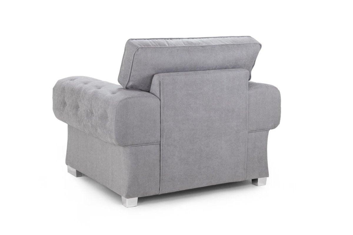 Back view of a grey upholstered armchair with tufted detailing and chrome legs