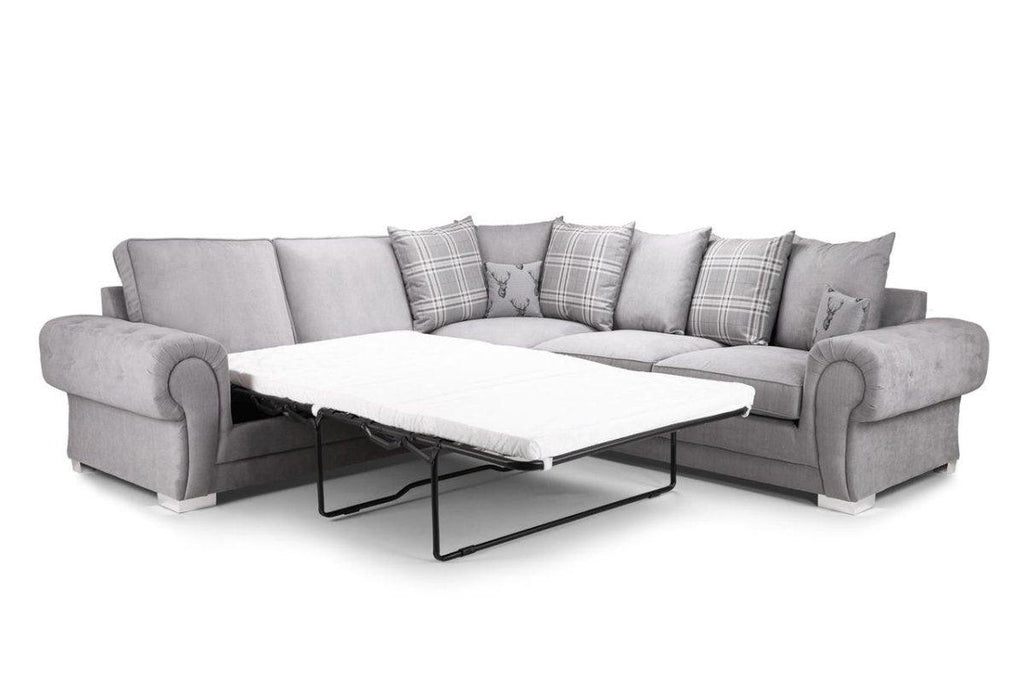 Grey corner sofa bed with scatterback cushions and plaid accents, extended sleeping area