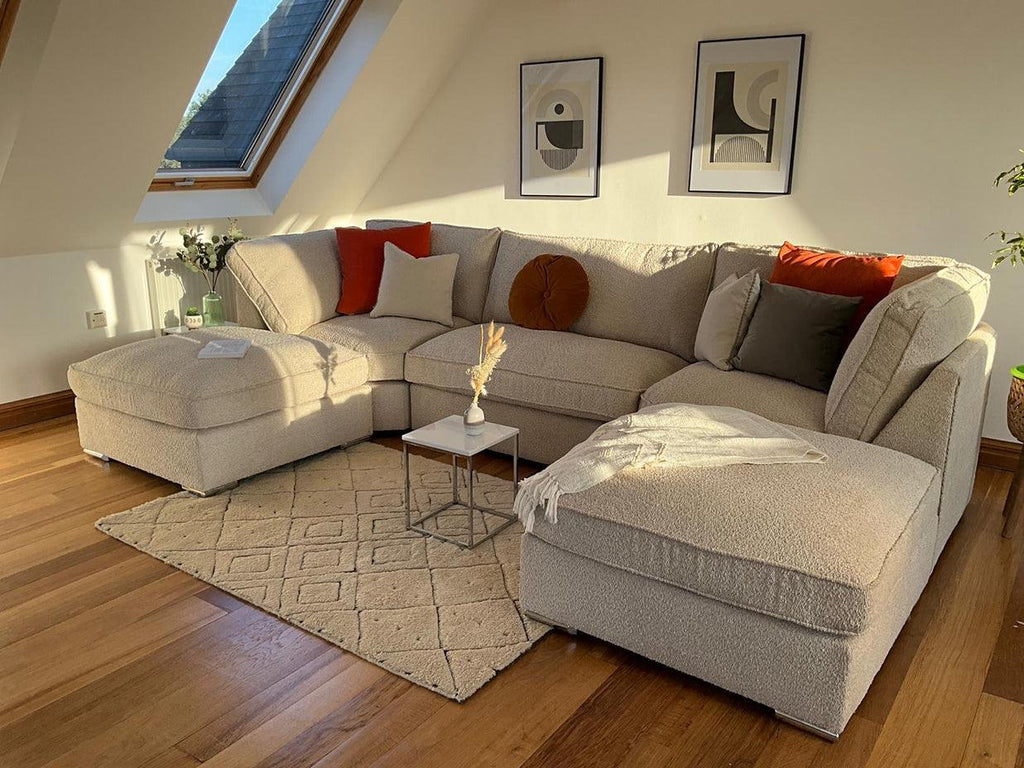 Large cream boucle U-shaped sofa in modern living room with wood floors and accent pillows