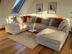 Large cream boucle U-shaped sofa in modern living room with wood floors and accent pillows