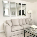 Modern cream 2-seater sofa with plush cushions in a stylish living room, under wall mirrors