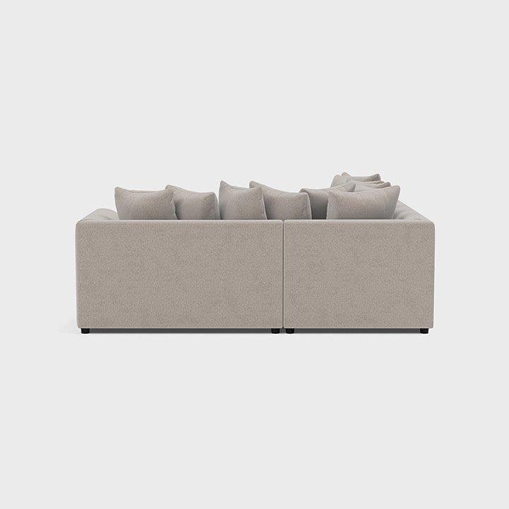 Cream double corner sofa with plush cushions, modern minimalist design on white background