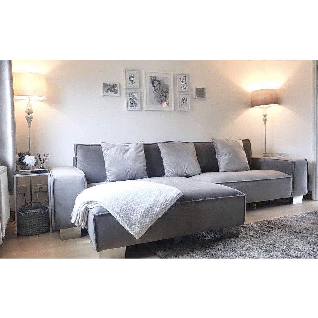 Large modern cream 4-seater sofa in a bright living room with lamps and wall art
