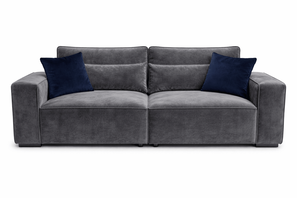 Modern grey velvet 4-seater sofa with wide arms and two navy blue throw pillows