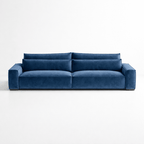 Modern blue velvet four-seater sofa with wide arms and deep cushions against a white background