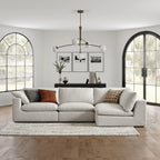Cream feather-filled corner sofa in a modern living room with large windows and minimalist decor.