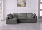 Cream corner sofa with feather-filled cushions in modern living room with light wood floors