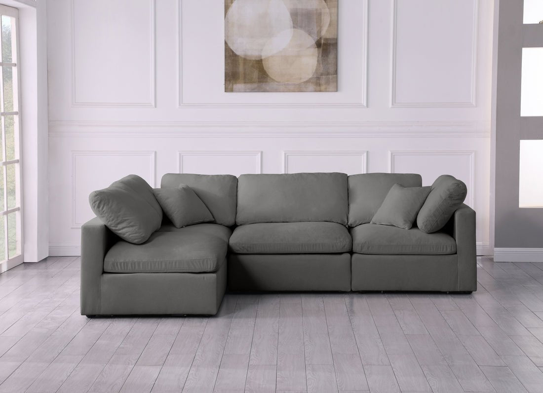 Cream corner sofa with feather-filled cushions in modern living room with light wood floors