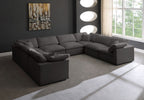Modern living room with a large gray U-shaped sectional sofa and natural light from big windows