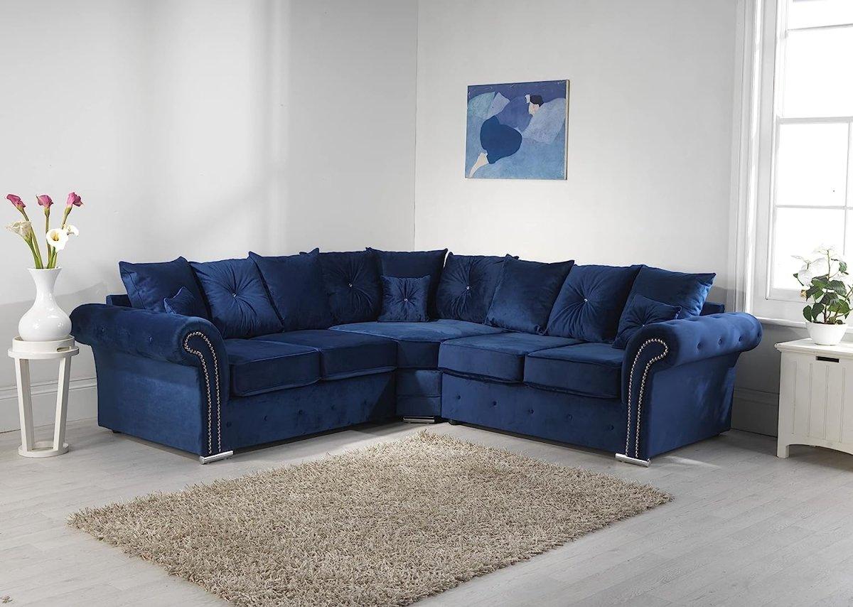 Blue velvet corner sofa with scatter back cushions in a modern living room