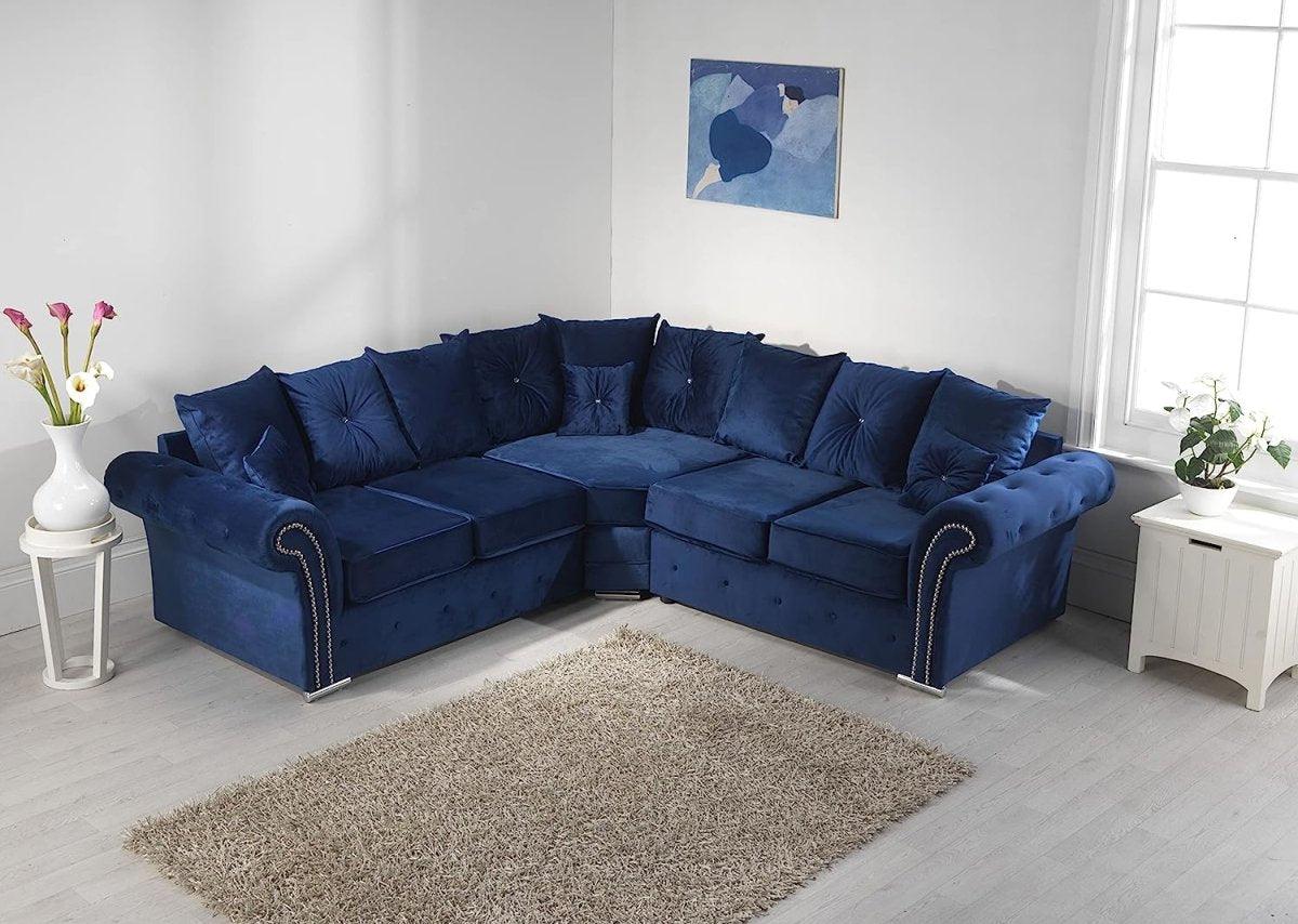 Navy blue corner sofa with plush scatterback cushions in a bright, modern living room