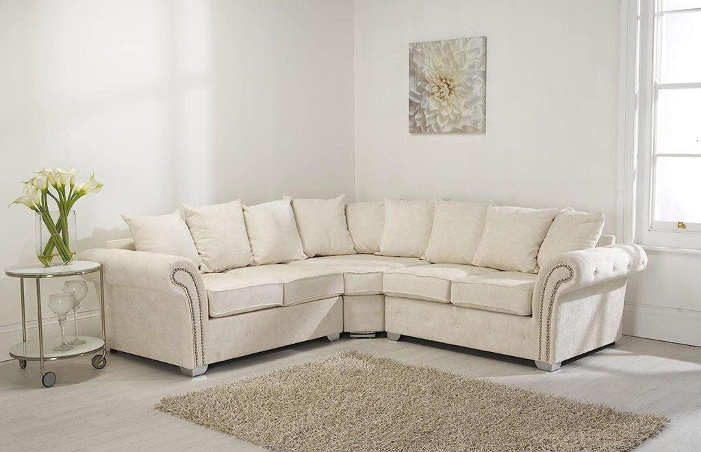 Cream corner sofa with scatter back cushions in a bright living room with neutral decor