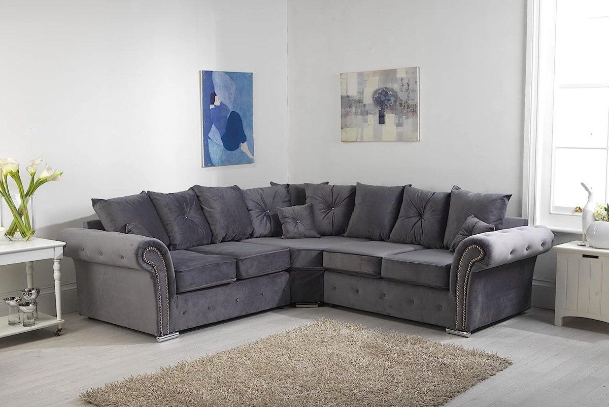 Grey velvet corner sofa with scatter back cushions in a bright living room