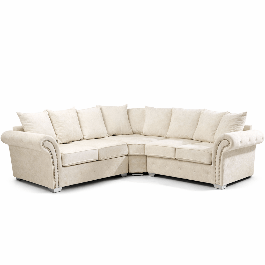 Cream corner sofa with scatterback cushions and rolled arms on chrome feet