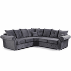 Grey velvet corner sofa with scatterback cushions and studded armrests