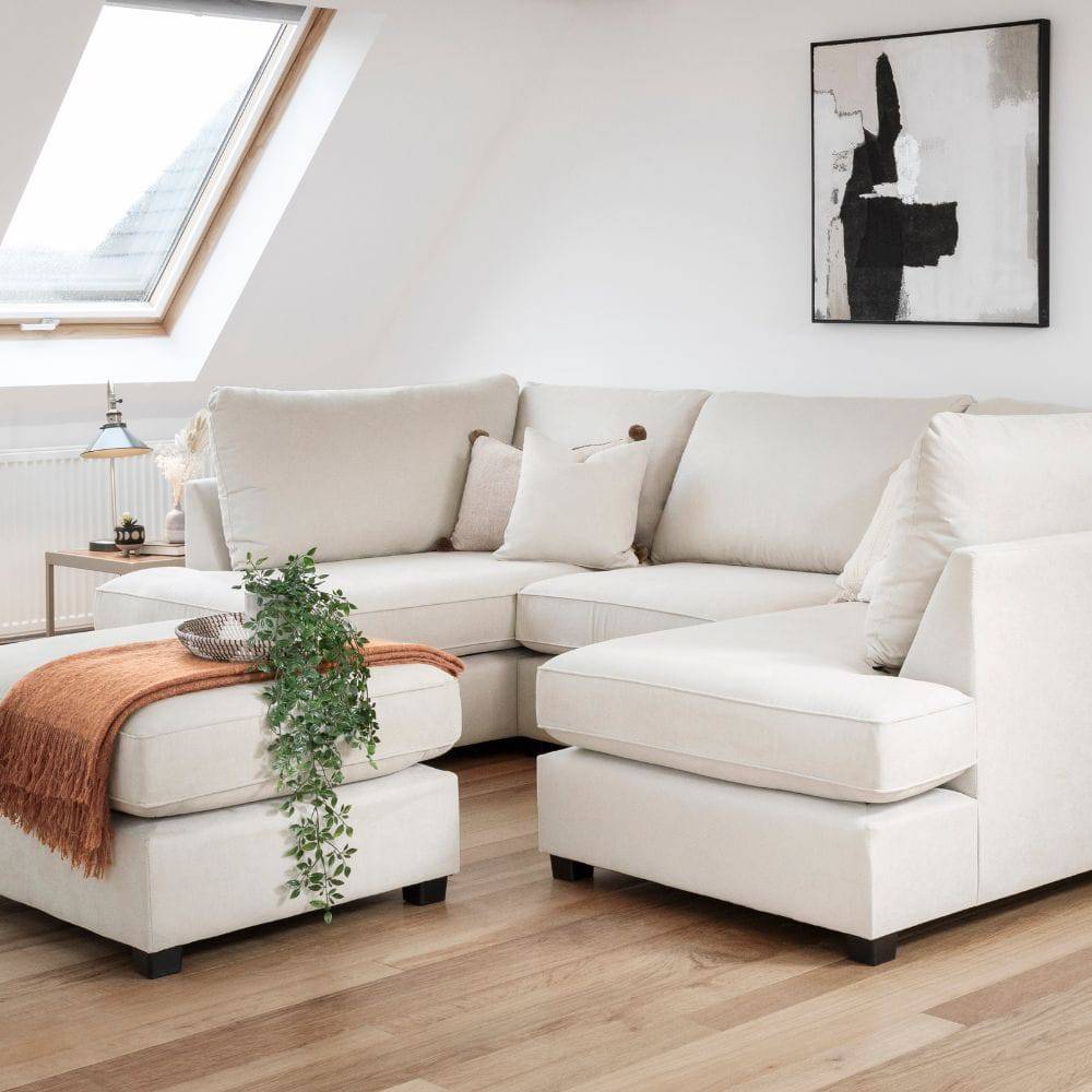 Plush cream U-shape sofa in modern loft living room with wood floors and neutral decor